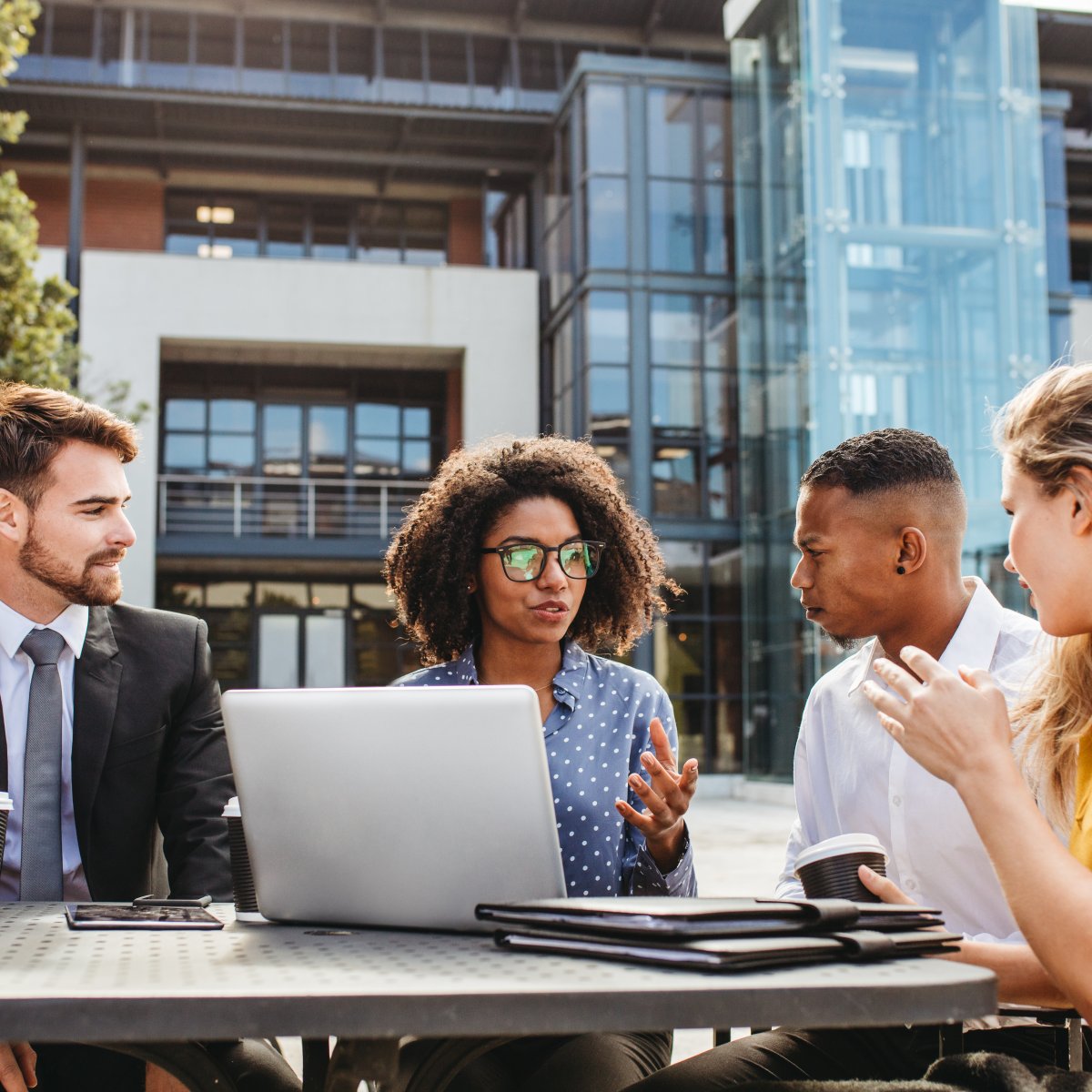 4 people having a meeting outside.